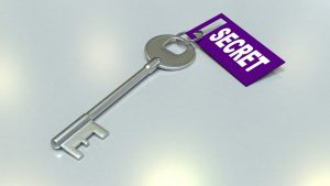 A silver skeleton/master/passkey has a purple tag attached to it with the word, “SECRET” attached.